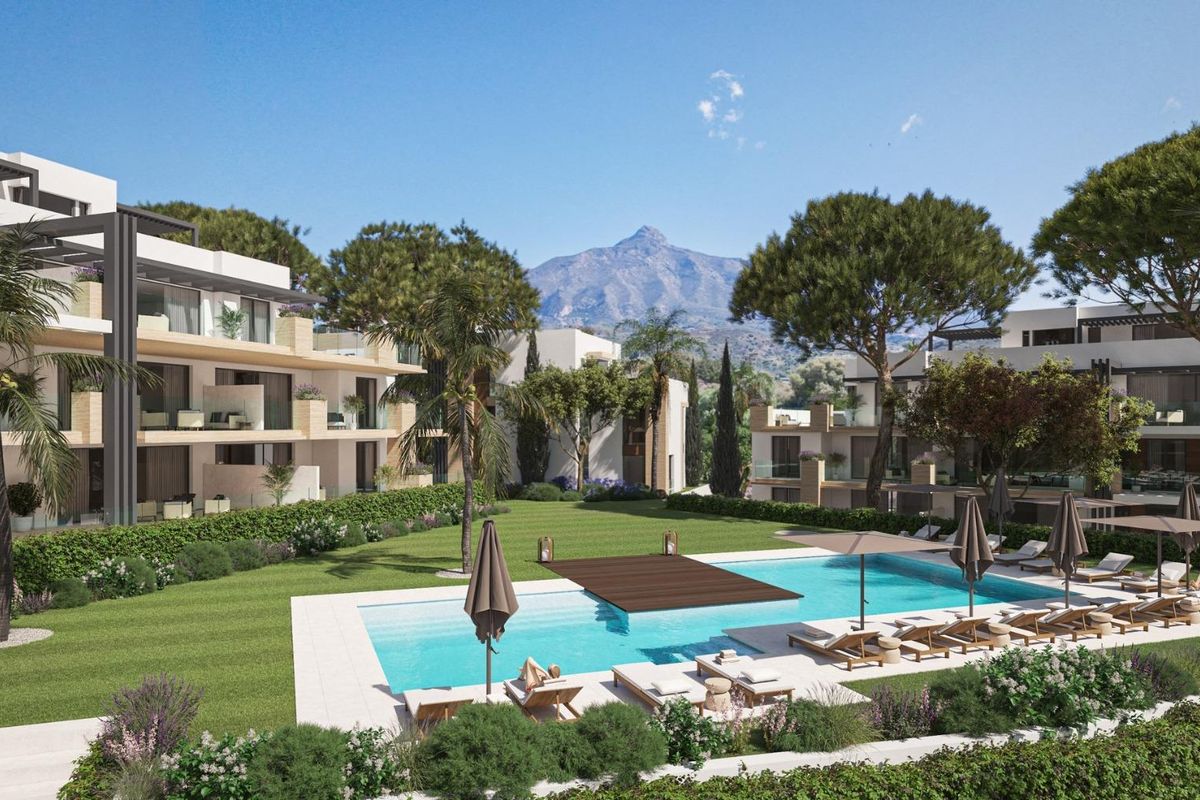 Buitenzicht op een modern appartementencomplex met een zwembad en aangelegde tuin in Marbella, Costa del Sol.