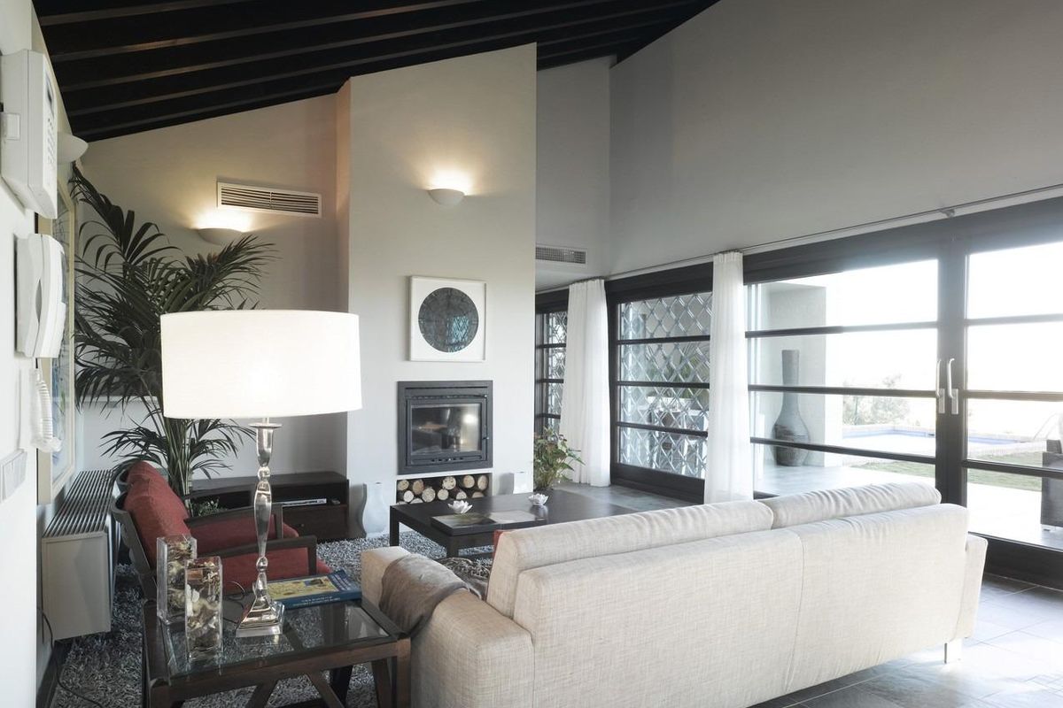 Uitnodigende woonkamer met een gezellige bank en open haard, gelegen in een 4-slaapkamer villa in Sucina, Costa Calida.