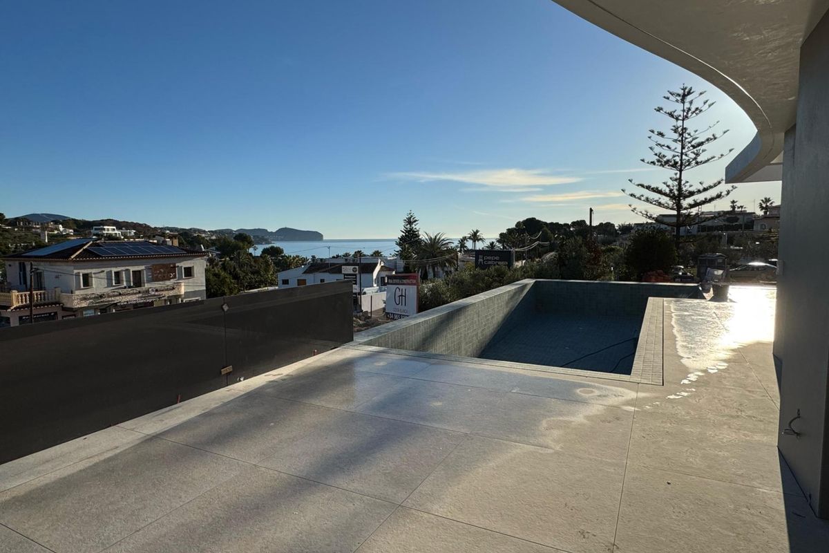 Buitenzwembad van een villa met 4 slaapkamers in Benissa, reflecterend de heldere lucht en moderne architectuur.
