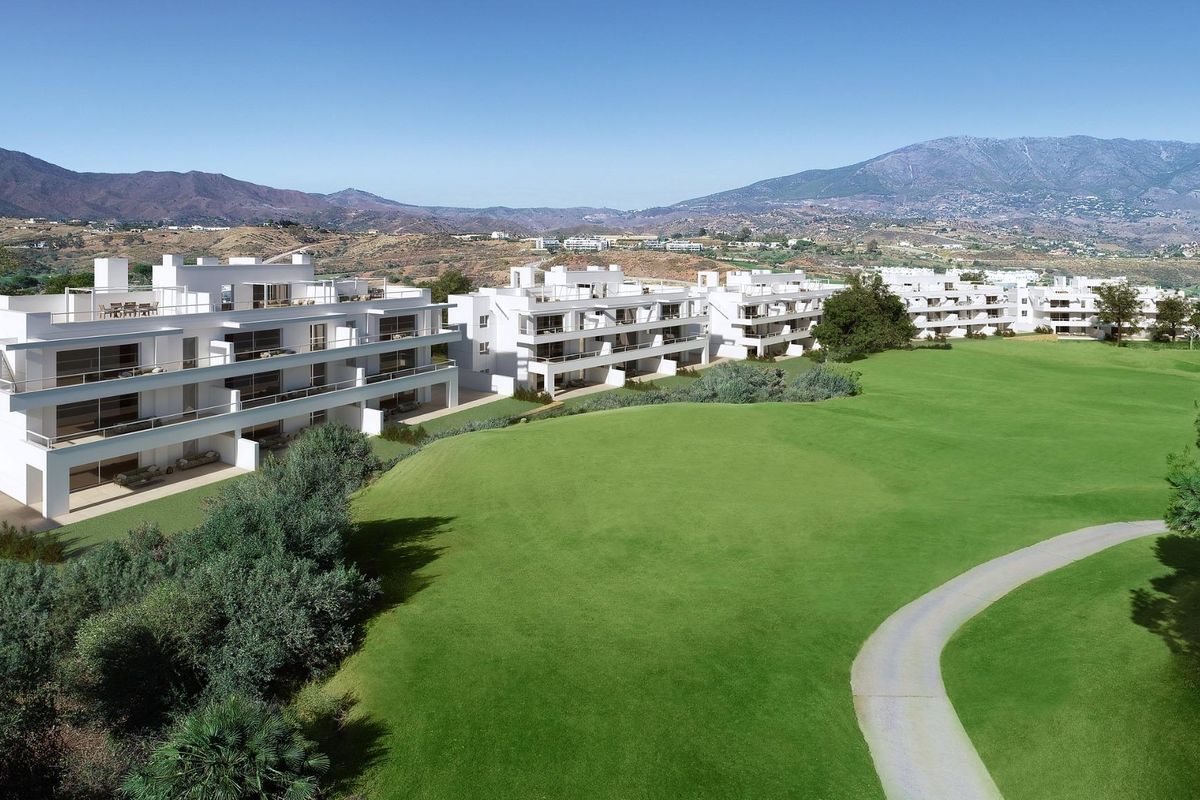 Luchtfoto van een modern appartementencomplex temidden van groene landschappen in Mijas, Costa del Sol.