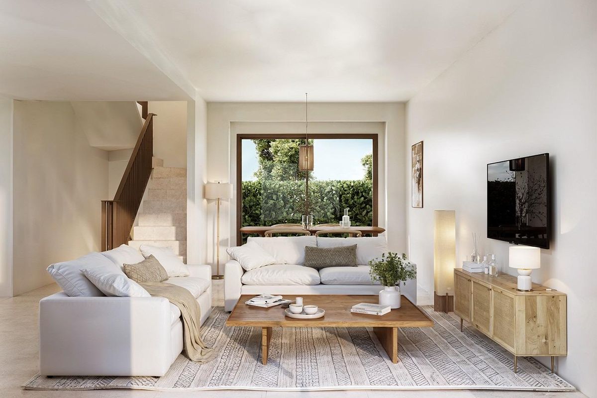 Gezellige woonkamer met witte meubels en uitzicht op de tuin van de 3-slaapkamerwoning in La Nucia.