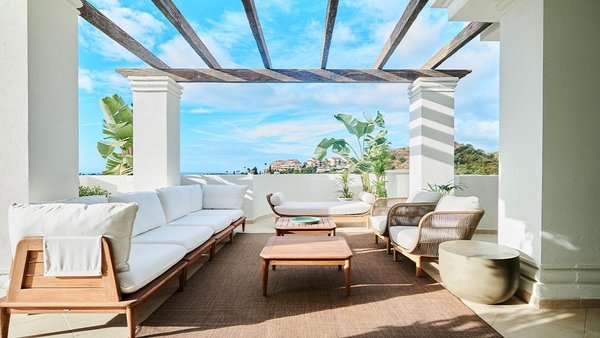 Stijlvol terras met zitplaatsen en uitzicht op de kust in Marbella, een luxe penthouse met 2 slaapkamers.
