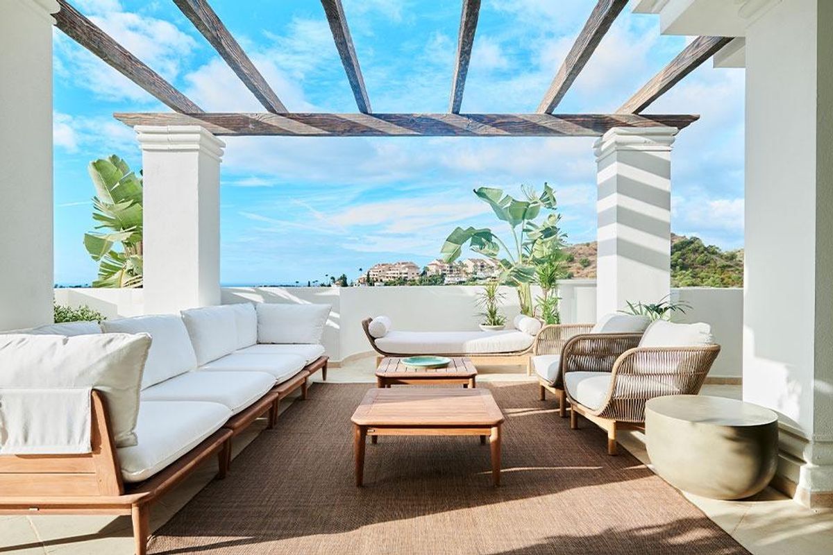 Stijlvol terras met zitplaatsen en uitzicht op de kust in Marbella, een luxe penthouse met 2 slaapkamers.