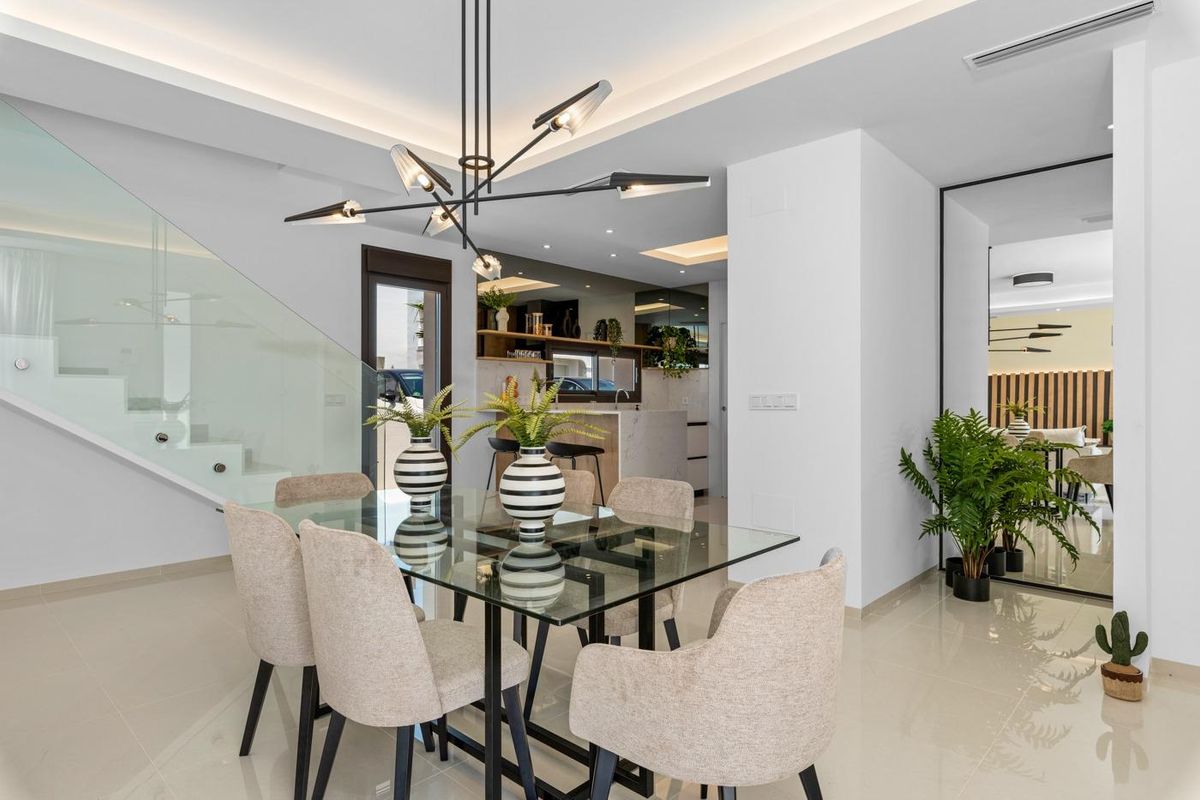 Eetruimte met moderne verlichting en decor, die leidt naar de keuken in een villa in Ciudad Quesada, Spanje.