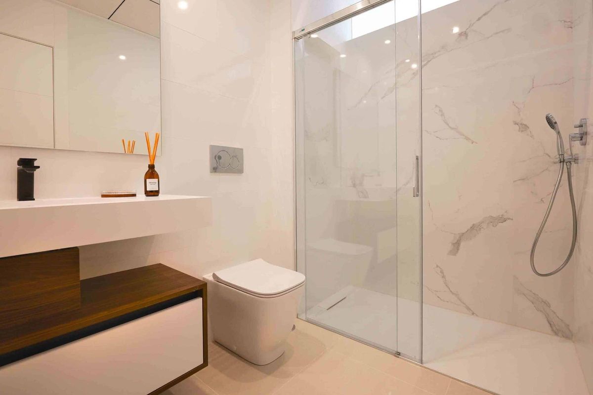 Ruimtelijke en moderne douche met elegante tegels in een badkamer van een appartement in Rojales, Costa Blanca Zuid, Spanje.