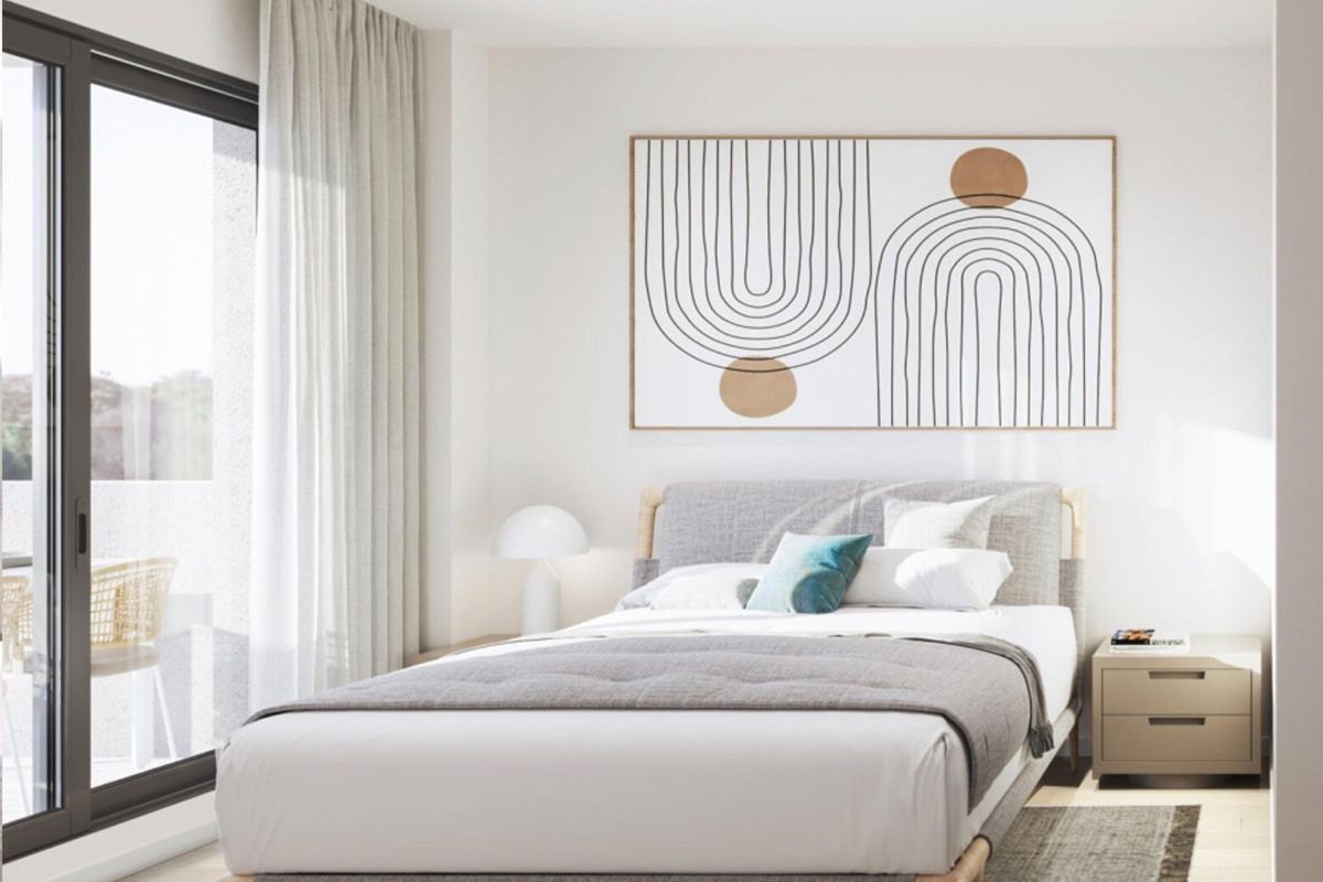 Helle slaapkamer met moderne kunstdecoraties en grote ramen in een penthouse in Torrevieja.
