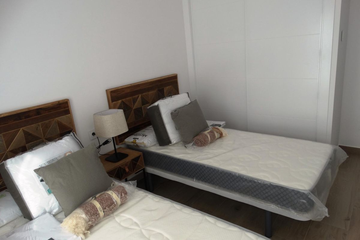 Ruime slaapkamer met twee bedden en smaakvol ontwerp in een townhouse in San Javier.