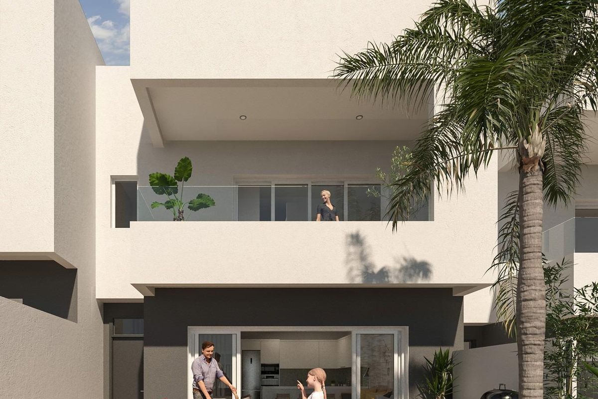 Gezin geniet van de tuin en het terras van een drie-slaapkamers rijtjeshuis in Monforte del Cid, Costa Blanca Zuid.