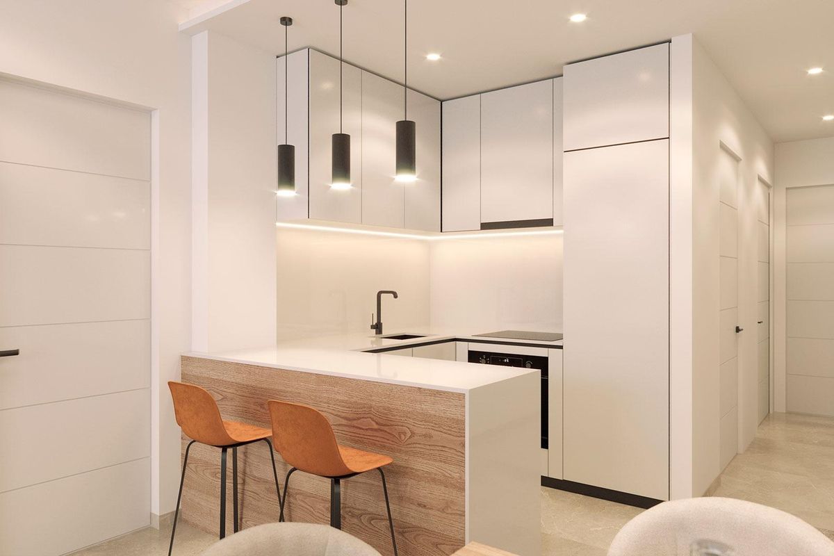 Moderne keuken met stijlvolle afwerkingen in een appartement in Torrevieja, met een ontbijtbar en strakke apparaten.