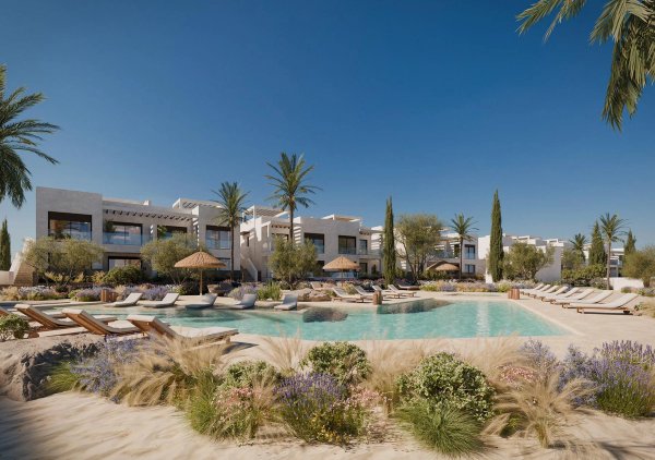 A pool area surrounded by lush vegetation and loungers at a Mojacar apartment complex.