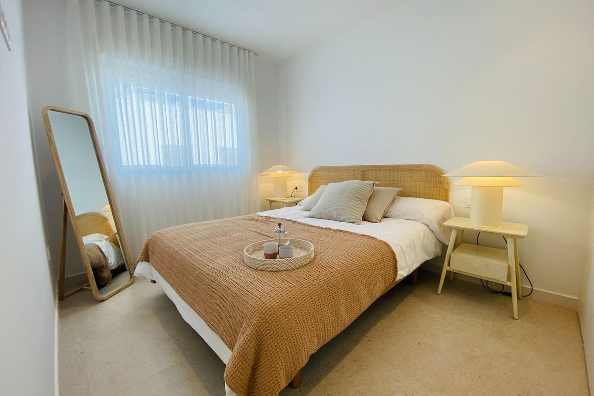 Gezellige slaapkamer met een neutraal kleurenpalet en groot raam in een 3-slaapkamer bungalow, Pilar de La Horadada.