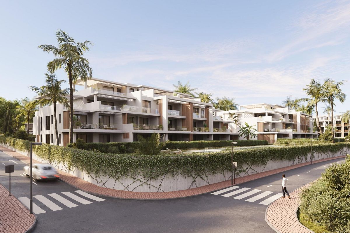 Brede kijk op het penthousecomplex vanuit de straat, met benadrukking van het ontwerp en omringend loof in Estepona.