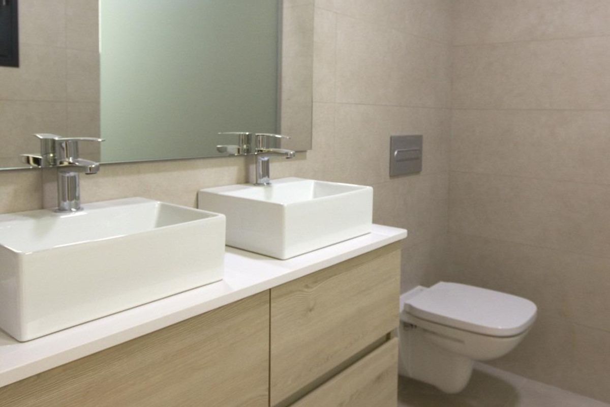 Modern badkamer met dubbele wastafels en eigentijdse armaturen in een appartement op de begane grond in San Fulgencio.
