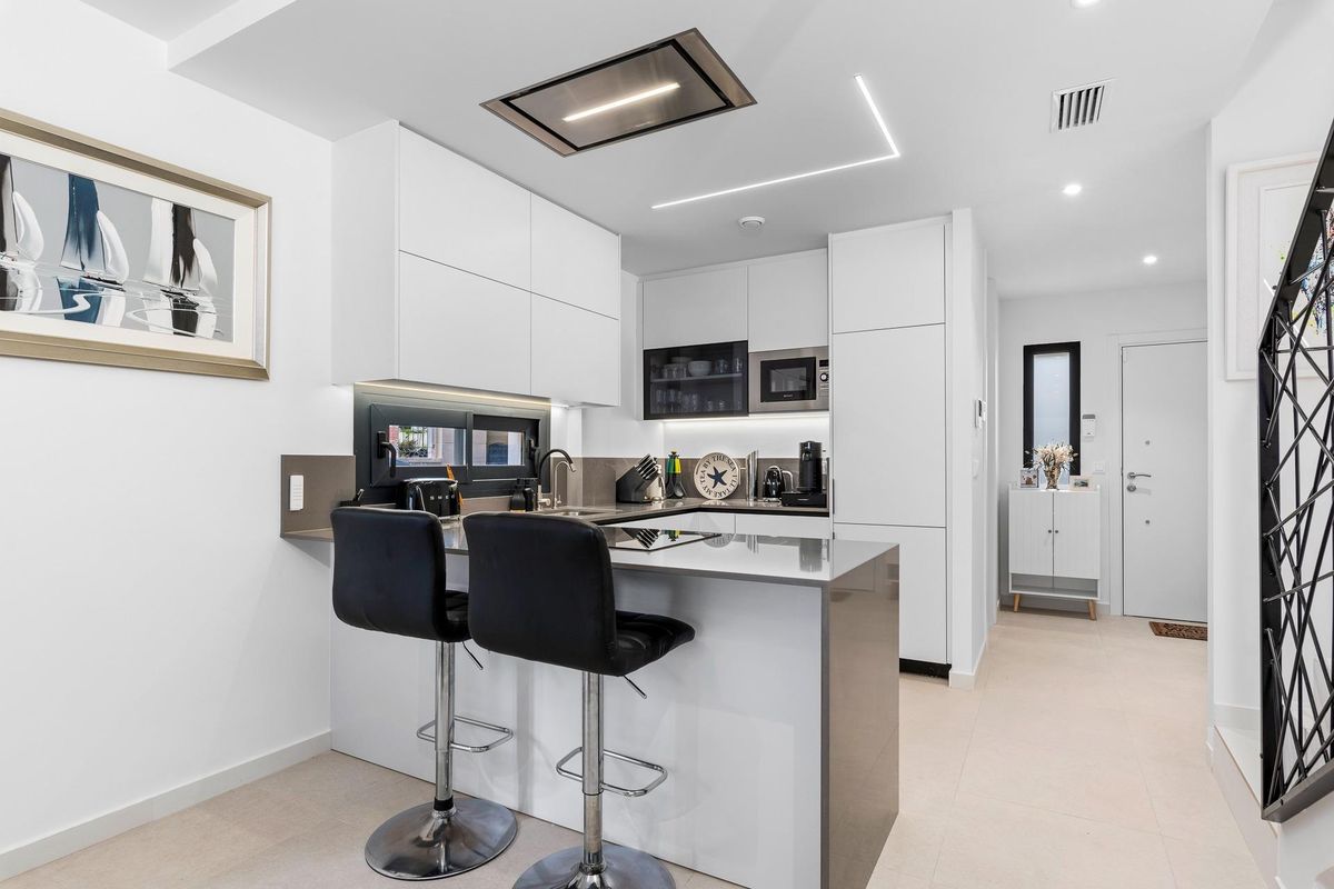 Stijlvol keukeneiland met barstoelen in een 4-slaapkamer townhouse in Guardamar del Segura, modern ontwerp.