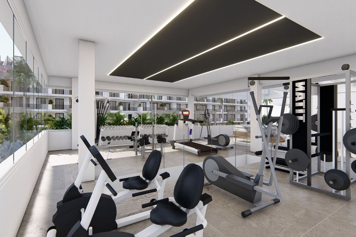 Goed uitgeruste gym in een appartementencomplex in Guardamar del Segura, met fitnessmachines en grote ramen.