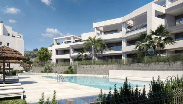 Buitenzicht op een modern appartementencomplex met zwembad en palmbomen in Estepona, Costa del Sol.