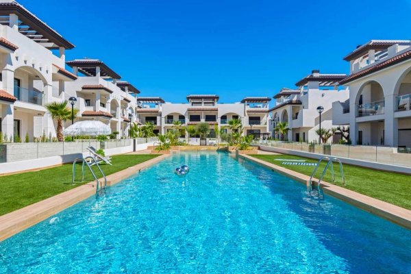 View of the swimming pool surrounded by modern apartments in Rojales, Costa Blanca South, Spain.