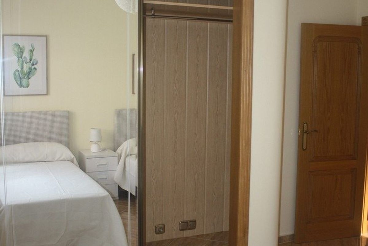 Tweepersoons slaapkamer met spiegelkast in de villa, die een frisse en luchtige sfeer toont.