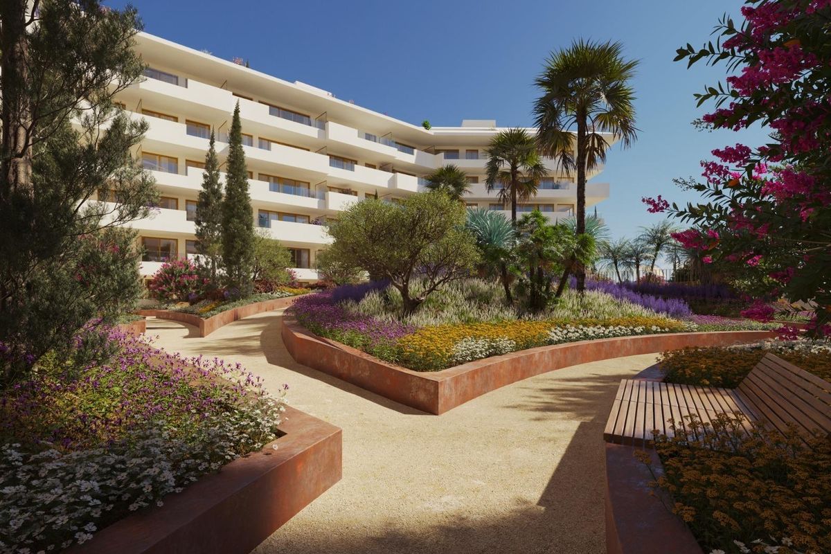 Goed ontworpen tuingedeelte met paden en bloemen bij een penthouse in Fuengirola.