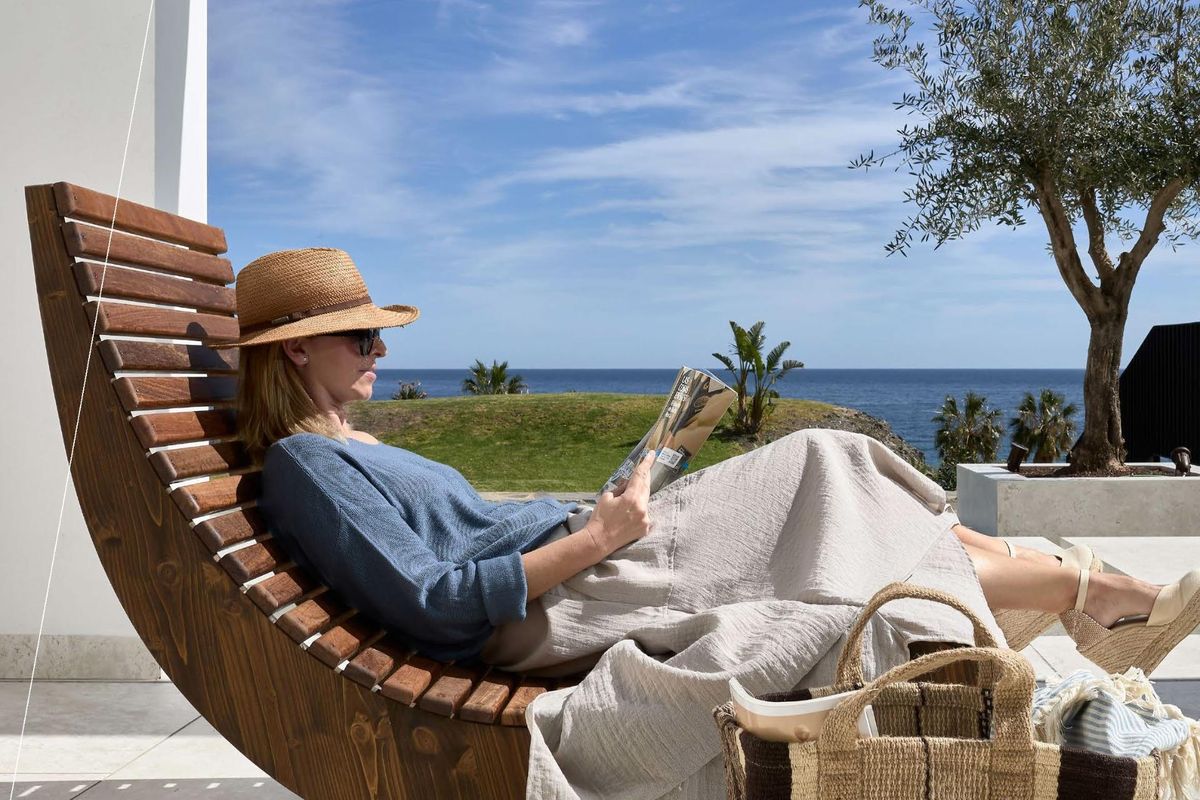Ontspannende scène van een vrouw die leest op een ligstoel in Mojacar, genietend van het uitzicht op de oceaan.
