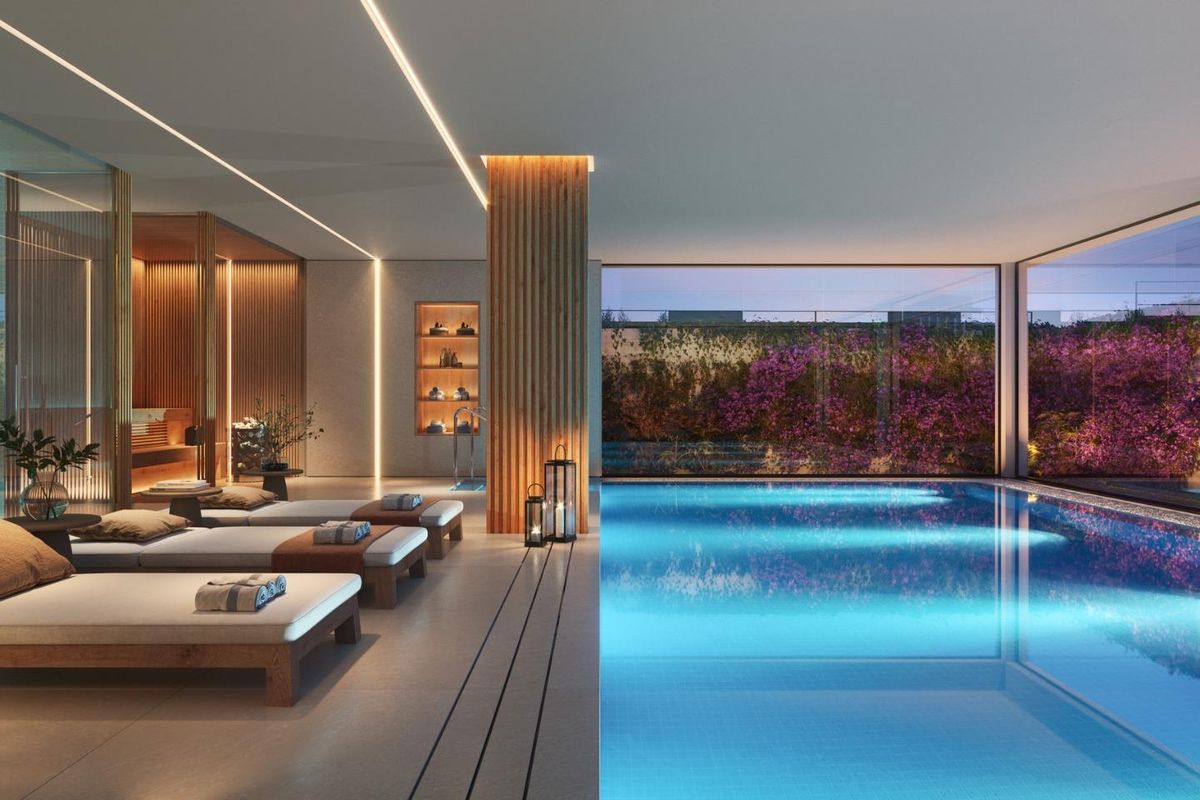 Elegant binnenzwembad met ligstoelen en prachtige tuinen, te vinden in een moderne villa in Marbella.