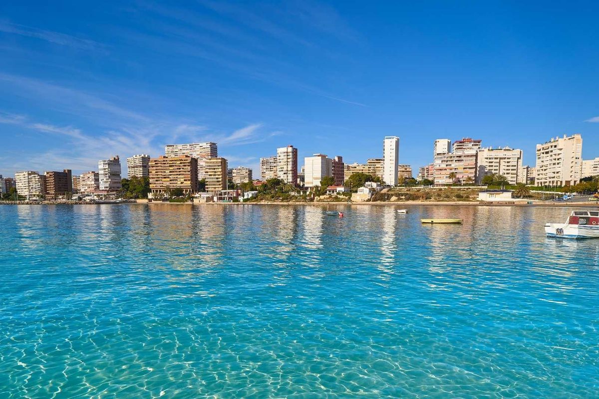 Kustlandschap van Els Poblets met indrukwekkende hoogbouw naast rustige wateren.