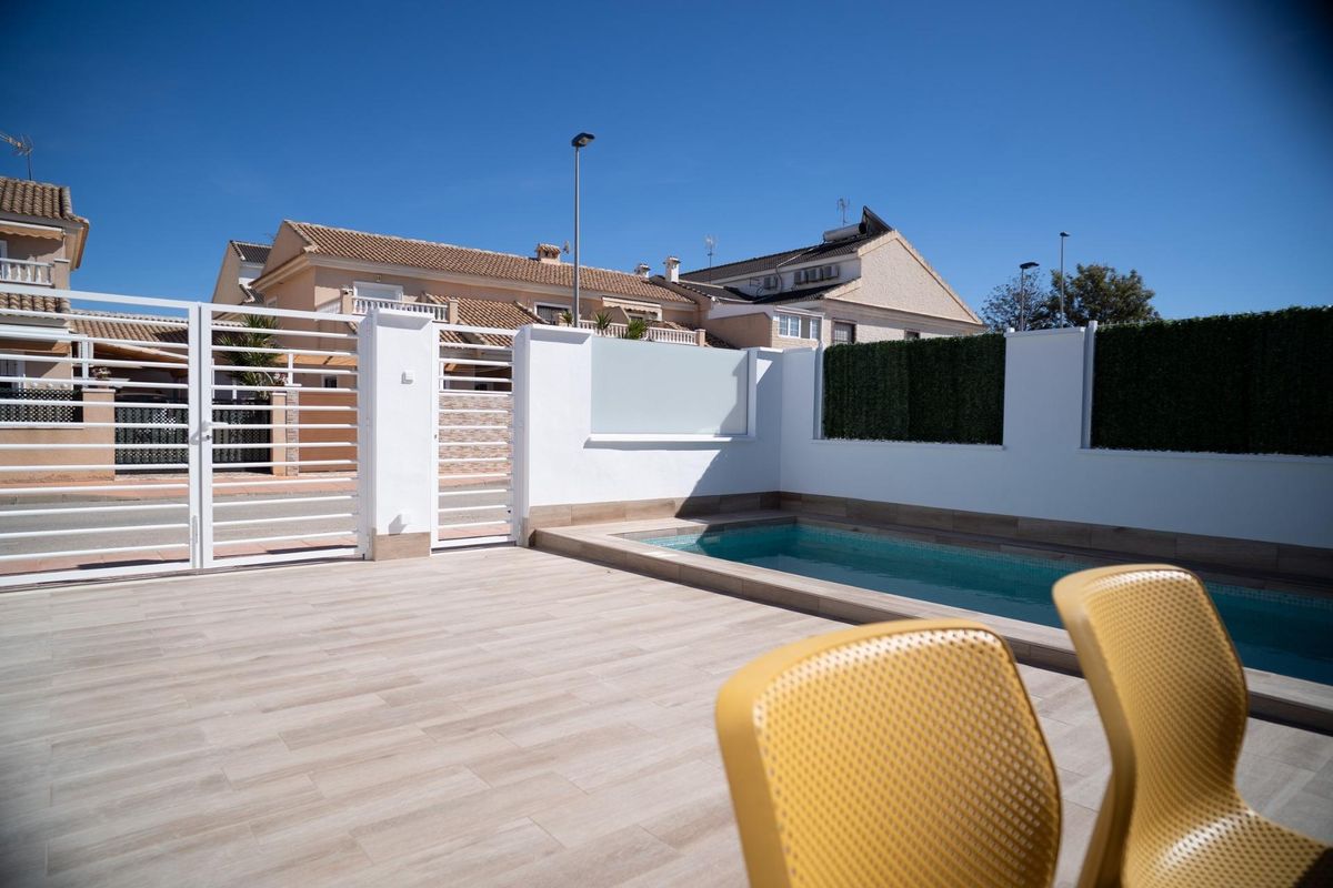 Pool and terrace area of a townhouse in San Javier, Spain. Yellow chairs can be seen in the foreground.