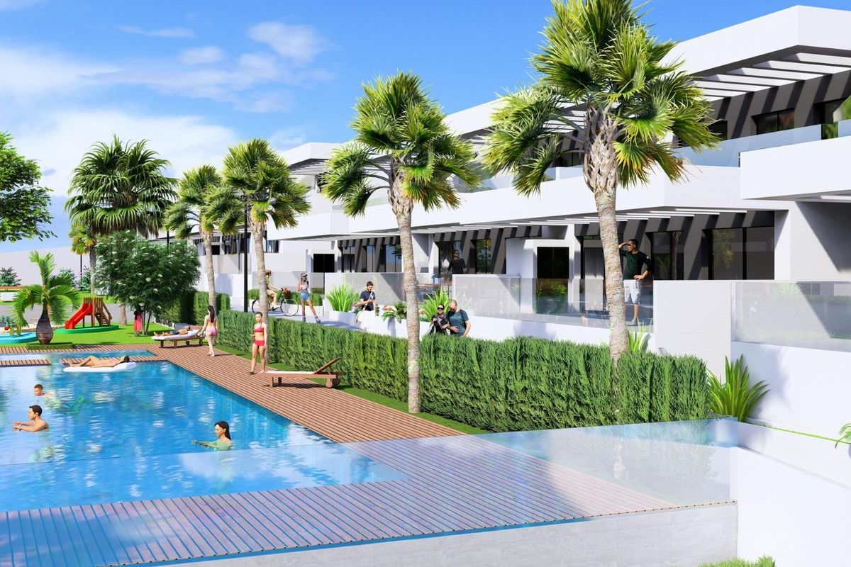 Buitenzwembad met groen en bewoners die het complex in Algorfa, Costa Blanca Zuid, genieten.