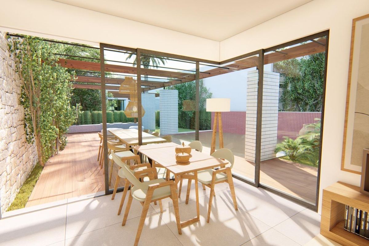 Lichtgevende eetruimte die naar een tuin opent, met een houten tafel en stijlvolle stoelen in Torre Pacheco villa.