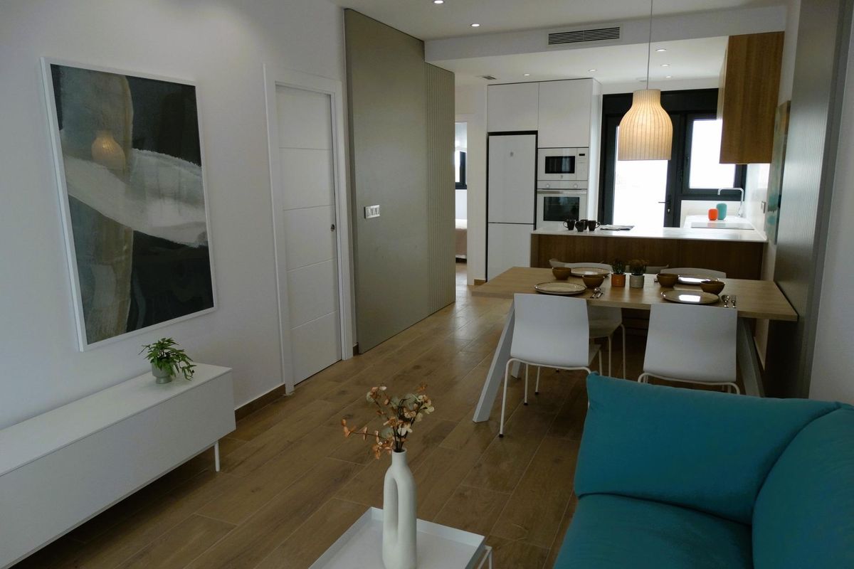 Uitzicht op de woonkamer met een teal bank, met moderne design in een 3-slaapkamer appartement in Spanje.