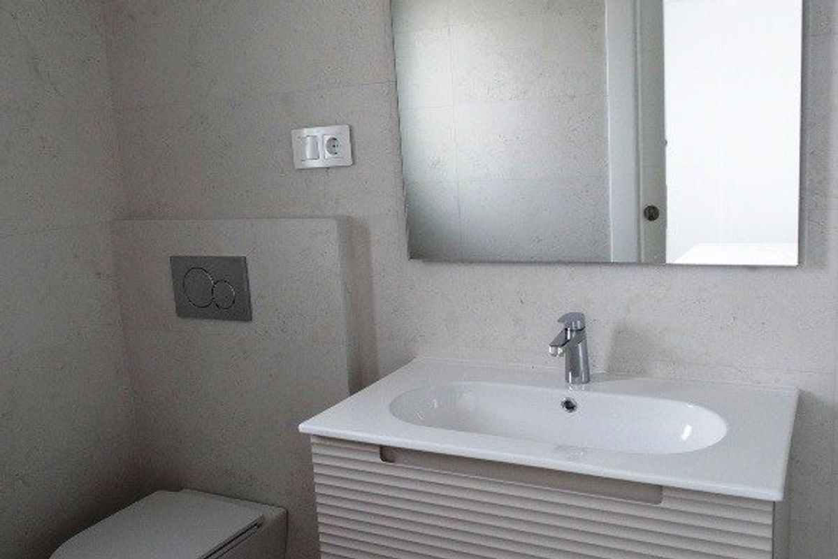 Chique badkamer met een ruime wastafel en minimalistisch ontwerp, gelegen in een townhouse in Pilar de La Horadada.