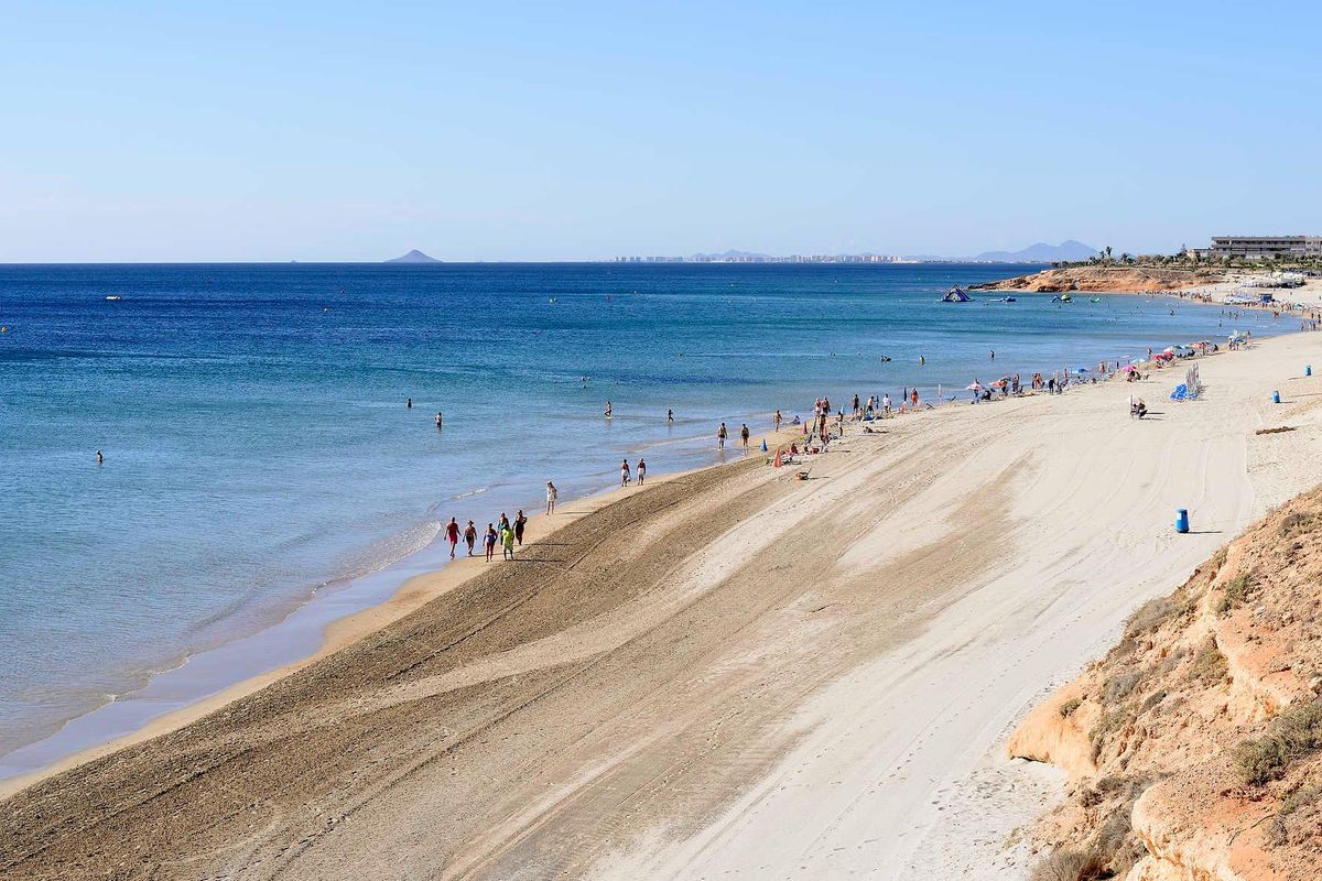 Prachtige zandkust met mensen die langs het strand wandelen nabij Pilar de La Horadada, Costa Blanca Zuid.