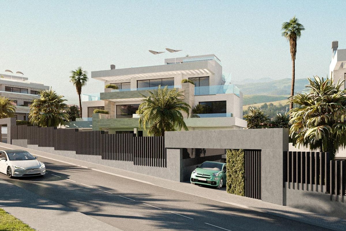 Nabijzicht van de moderne gevel van een 2-slaapkamerappartement in Estepona, met weelderige beplanting.