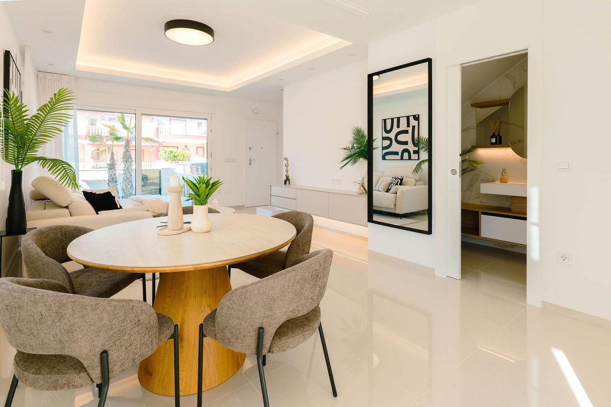 Elegante eetruimte met een ronde tafel en stijlvolle stoelen in de woonruimte van een townhouse in Rojales.