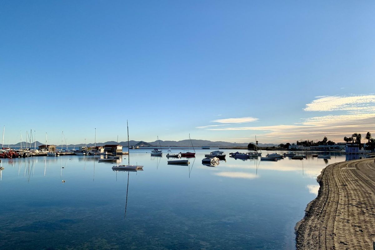 Schilderachtig uitzicht op kalm water en boten bij zonsopgang in Los Alcazares, Costa Calida.