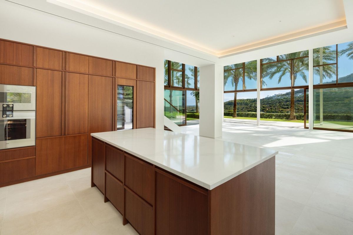 Gourmetkeuken met een kookeiland en ruime ramen die uitzicht geven op de tuinen, Casares, Costa del Sol.