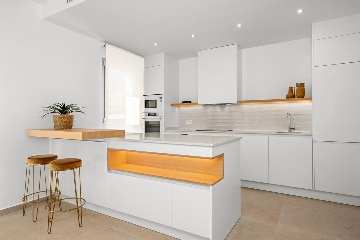 Contemporary keuken eiland in villa in Benijofar, met barkrukken en elegante verlichting boven de toonbank.