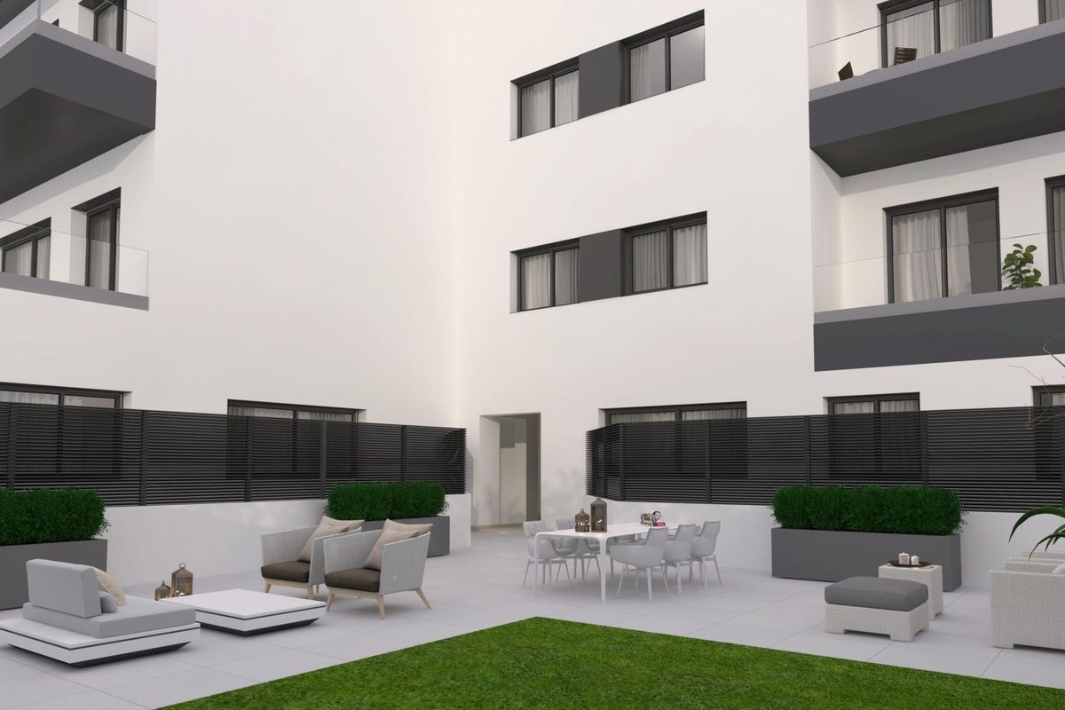 Modern uitzicht op een binnenplaats van een 1-slaapkamer appartement in Málaga, met zithoek en eethoek.