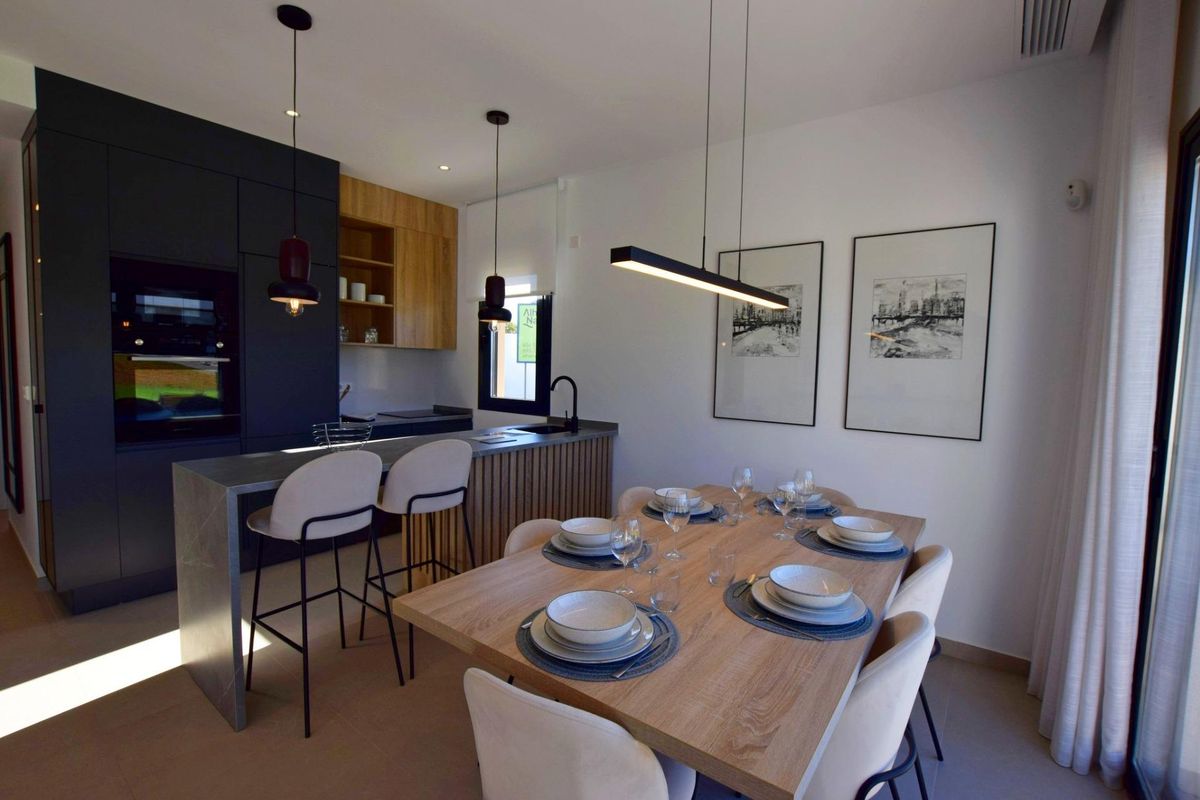 Moderne eetkamer met een stijlvolle tafel en keuken in een 3-slaapkamerappartement in Alhama De Murcia.