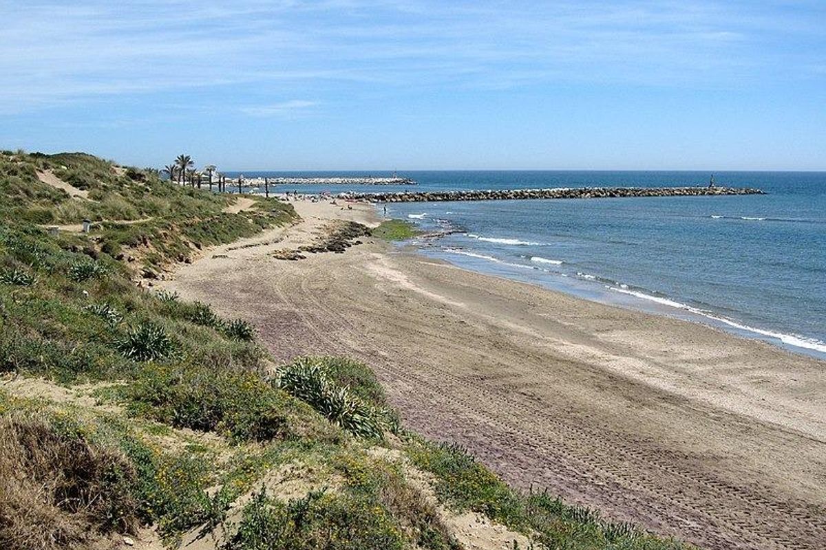 Schilderachtig strand in Marbella met zandstranden en kalme golven, populair om te ontspannen en voor watersporten.