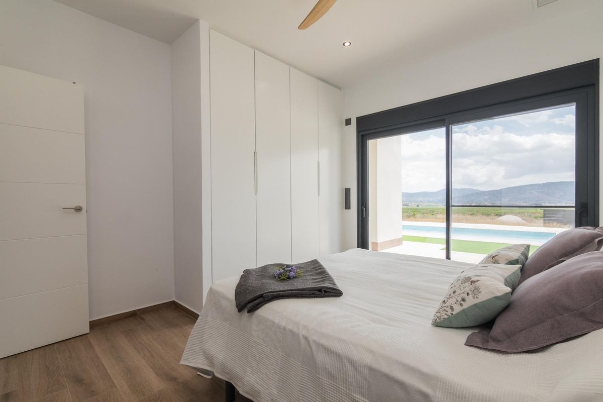 Elegant bedroom view in a Pinoso villa, showcasing natural light and stylish furnishings.