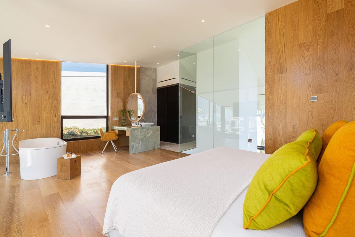 Hoofdslaapkamer met en-suite badkamer in een 4-slaapkamer herenhuis in fuengirola, met houten lambrisering en moderne armaturen.