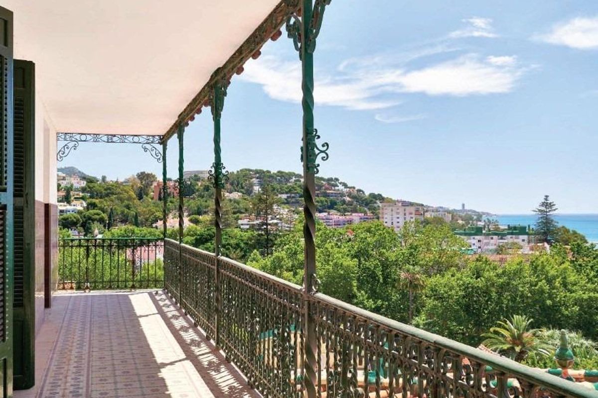Balkon uitzicht dat weelderige groene omgeving en schilderachtige kustlijn in Málaga, Costa del Sol toont.