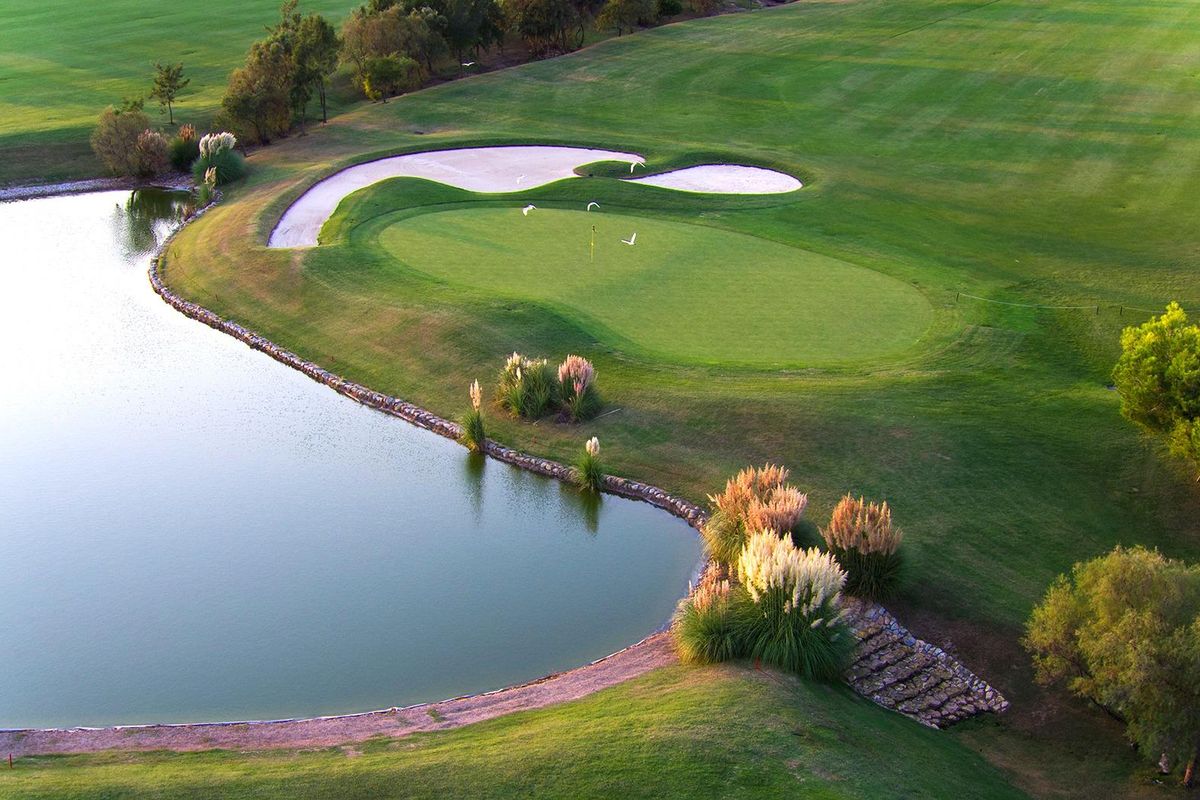 Een rustige golfgreen naast een vijver met mooie landschapsarchitectuur in Pilar de La Horadada, Costa Blanca Zuid.