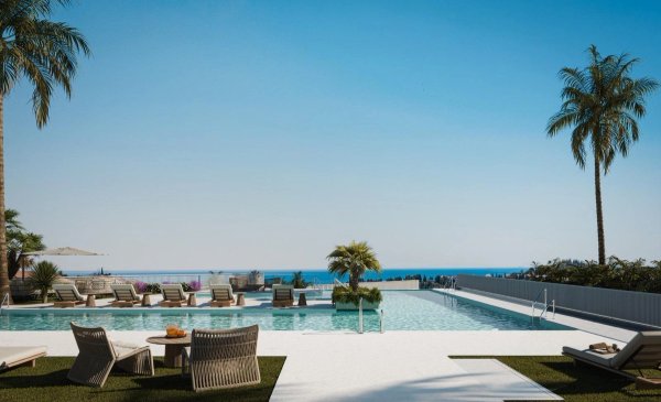 Prachtig uitzicht op een zwembad met ligstoelen en palmbomen in Mijas, Costa del Sol.