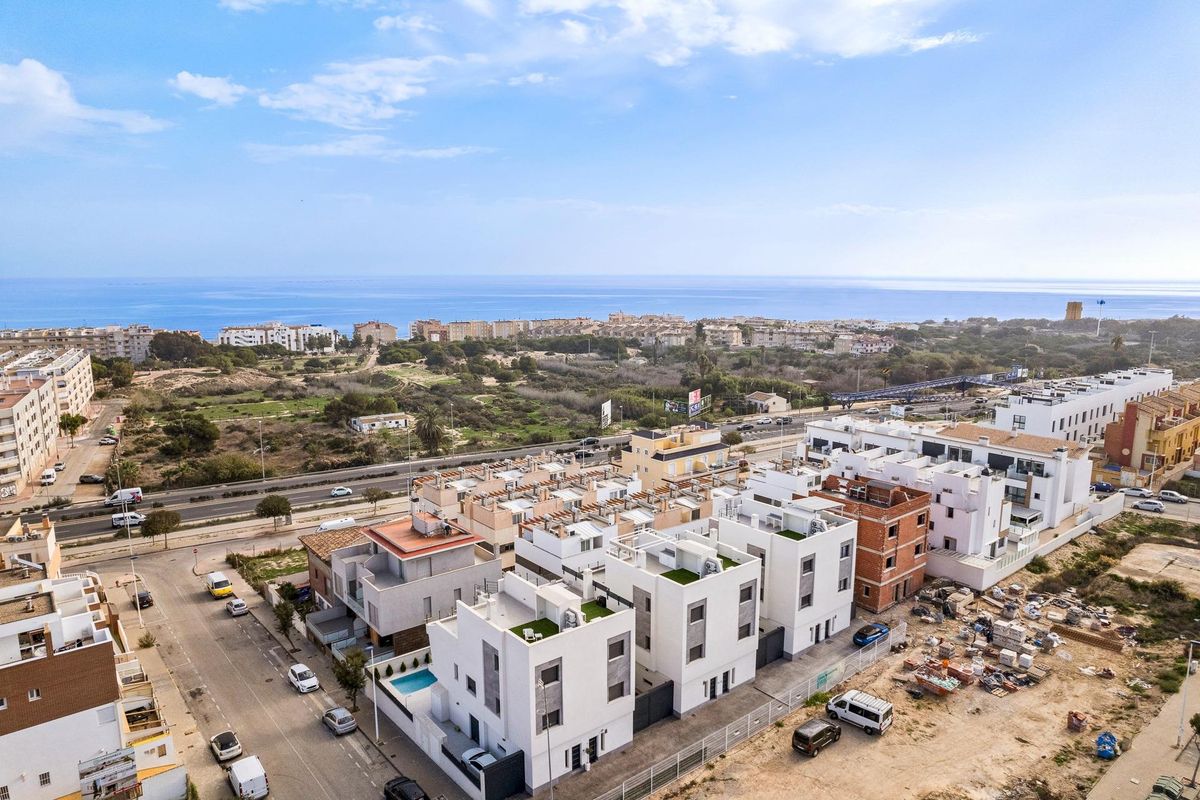 Luchtfoto van een nieuwe woningontwikkeling nabij de kust, met moderne stadswoningen in Costa Blanca Zuid.