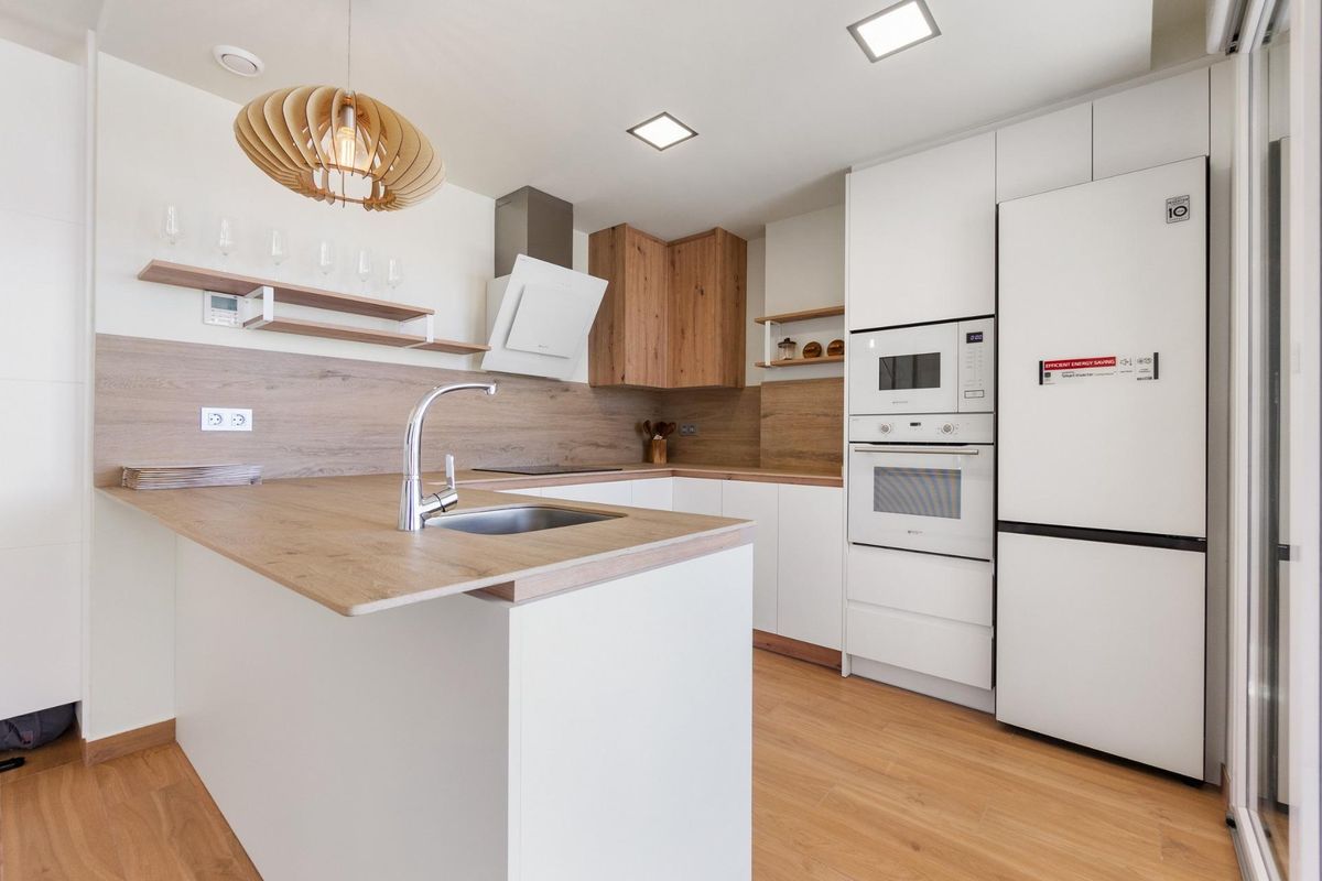 Moderne keuken met strak ontwerp en houten accenten in de 3-slaapkamer villa in Rojales, Spanje.