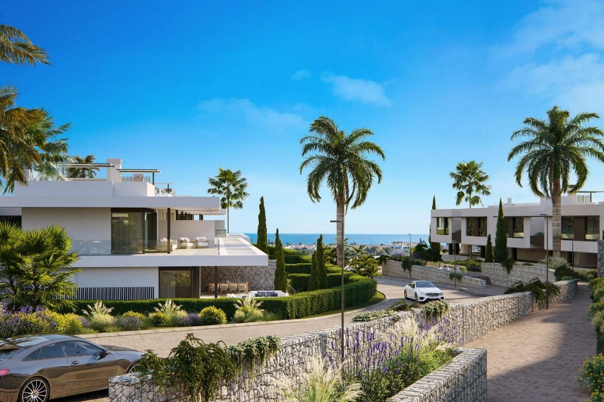 Schilderachtige weg omzoomd met palmbomen die naar luxe bungalows in Marbella, Costa del Sol leidt.