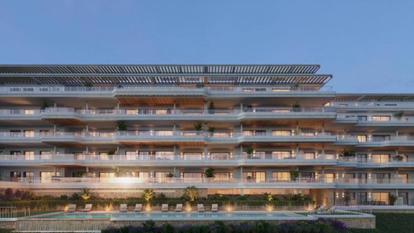 Buitenzijde van een modern appartement van 2 slaapkamers in Torremolinos, met meerdere terrassen en avondverlichting.