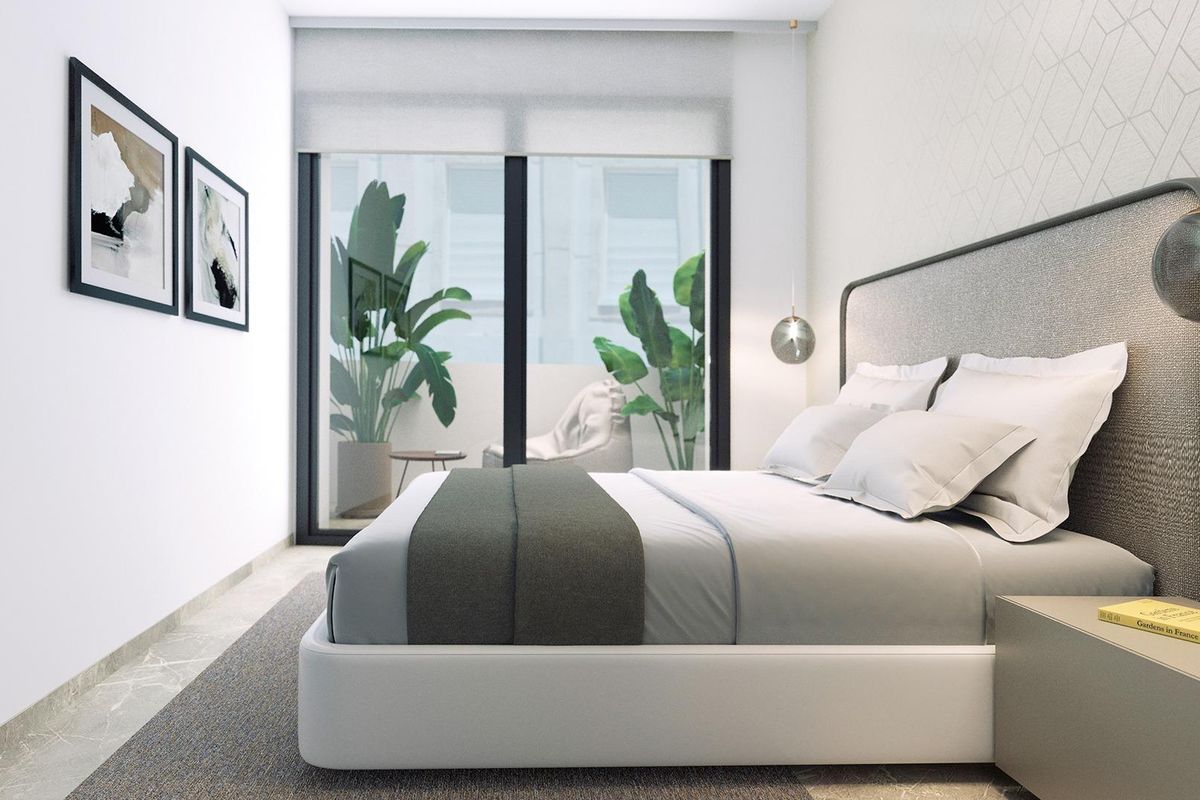 Elegante slaapkamer met een groot bed en natuurlijk licht in het penthouse van Torrevieja.